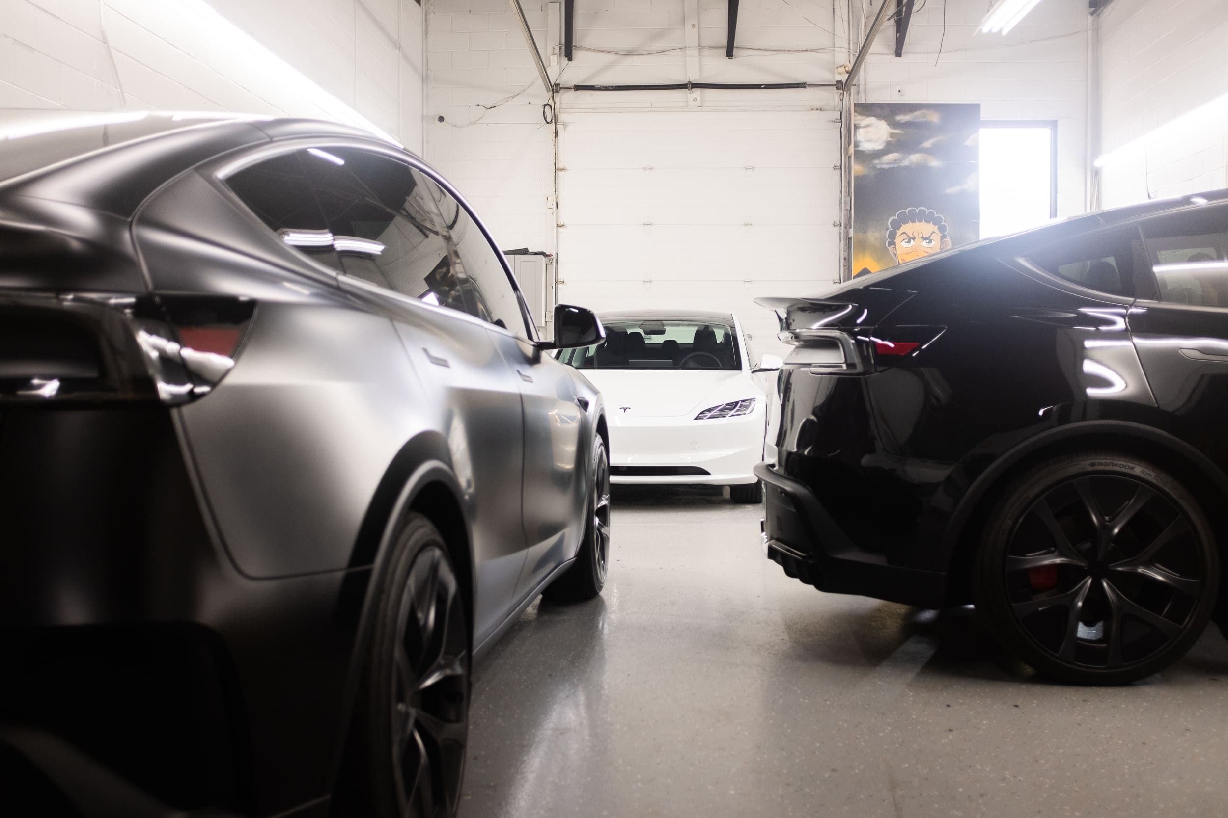 picture of a shop with 3 modern teslas 2026